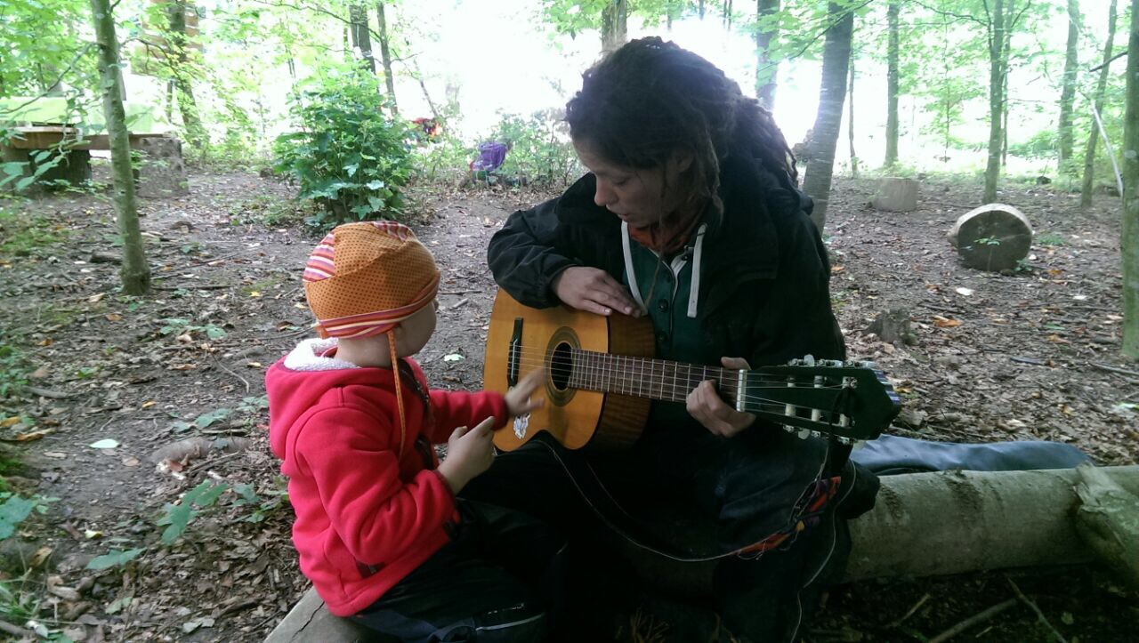 Ein Kind untersucht eine Gitarre.